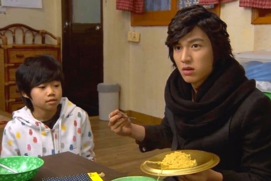 People eating Korean ramen from a metal lid